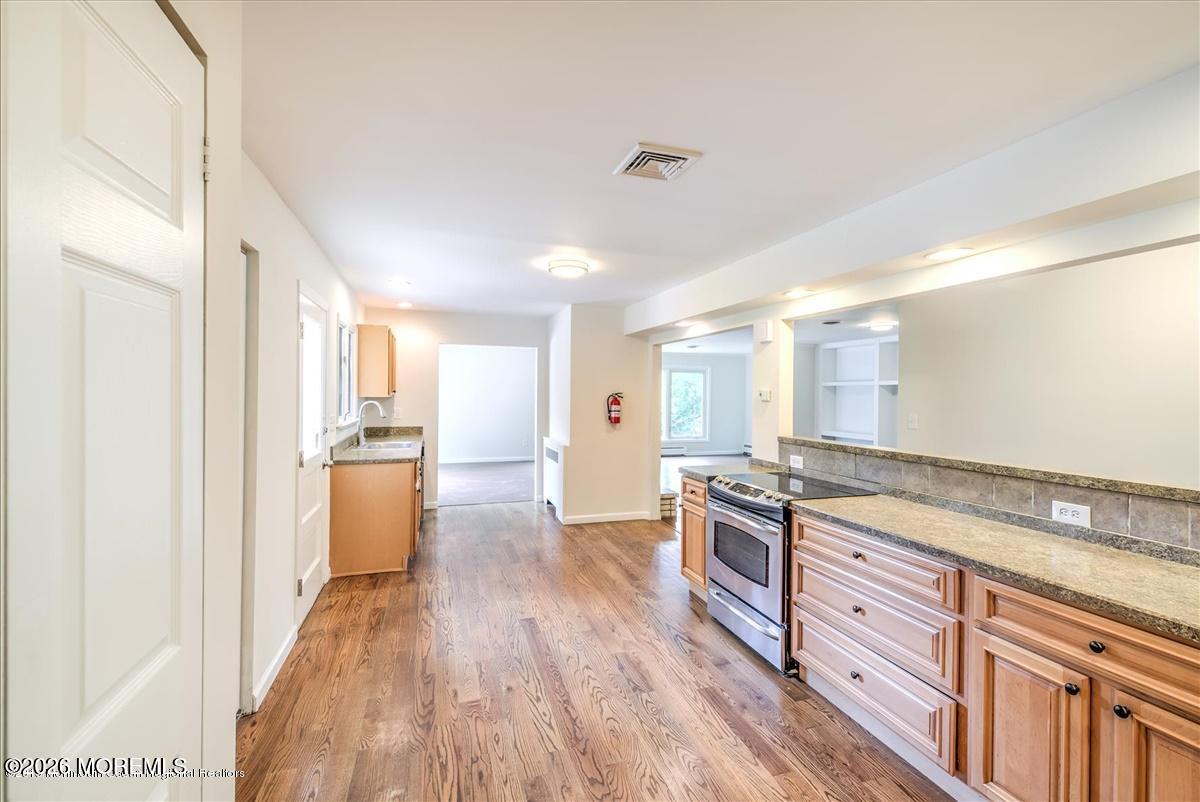 699 Aldrich Road Howell, NJ 07731 - Photo 4 of 23 a kitchen with granite countertop a stove a sink and a refrigerator