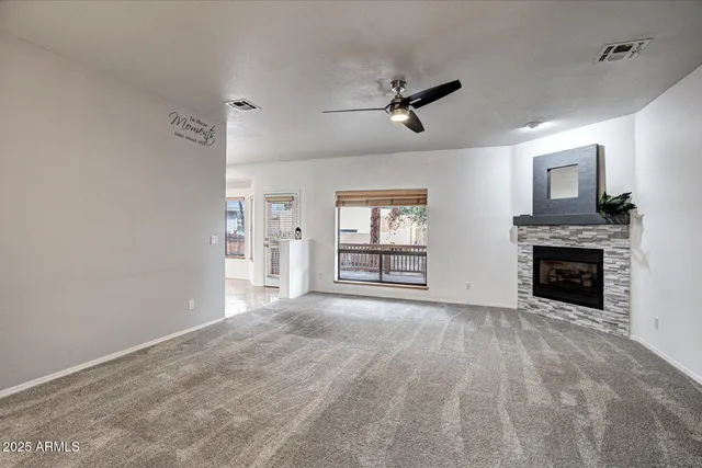 a view of empty room with fireplace and ceiling fan