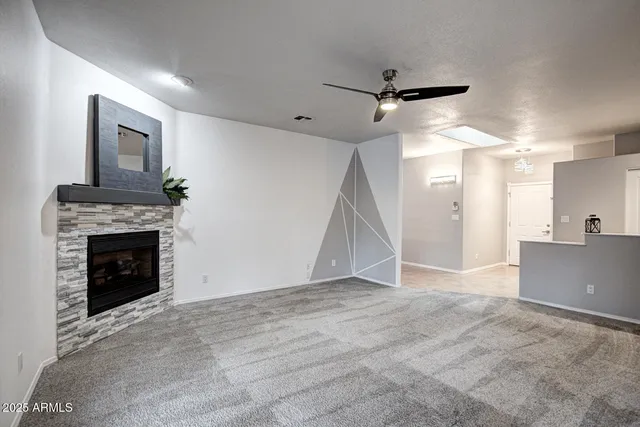 a view of a big room with windows and chandelier fan