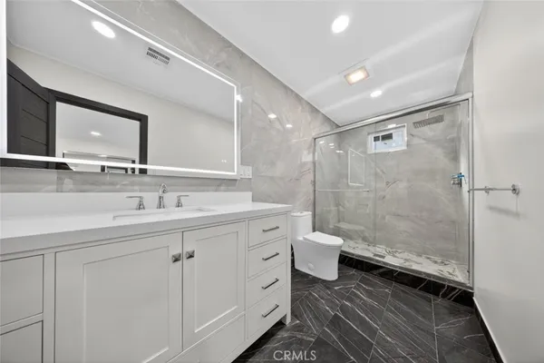 a bathroom with a double vanity sink toilet and shower