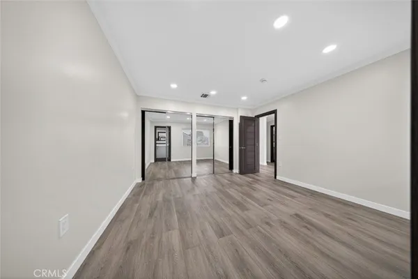 a view of an empty room with wooden floor