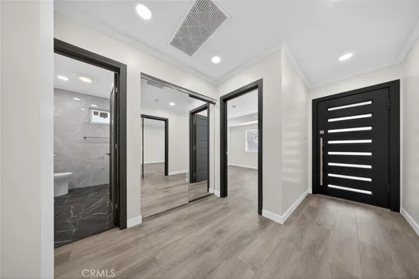wooden floor and closet in a hall with an entryway