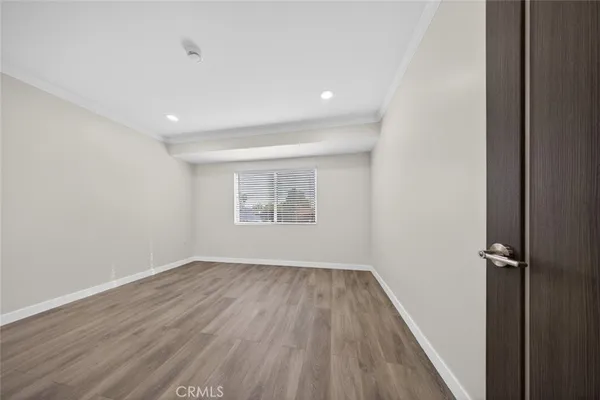 an empty room with wooden floor and a ceiling fan