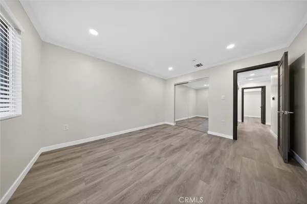 a view of empty room with wooden floor