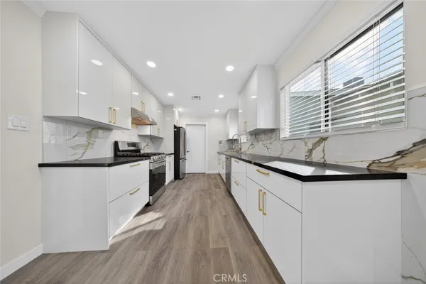 a kitchen with granite countertop a sink and cabinets