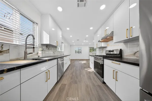 a kitchen with stainless steel appliances granite countertop lots of counter space sink and cabinets