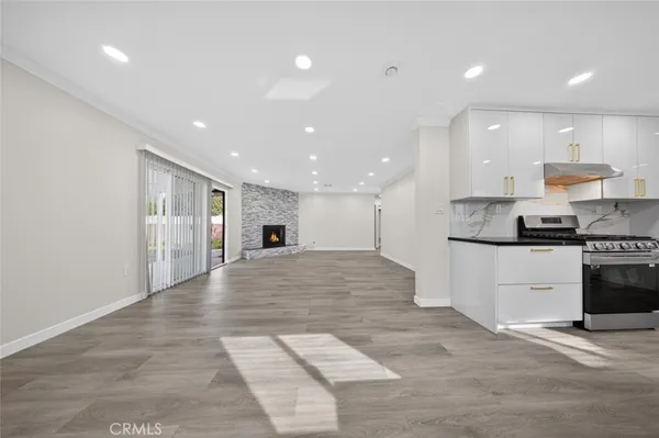 a large kitchen with stainless steel appliances kitchen island a large counter top and a stove top oven