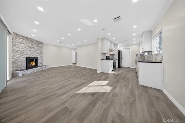 a view of kitchen with kitchen island wooden floor center island and stainless steel appliances