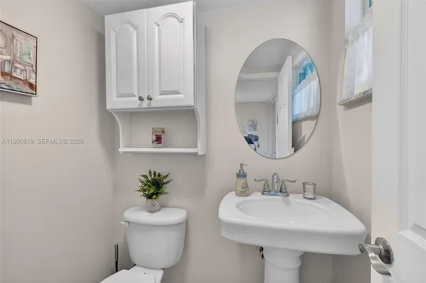 a bathroom with a toilet sink and mirror