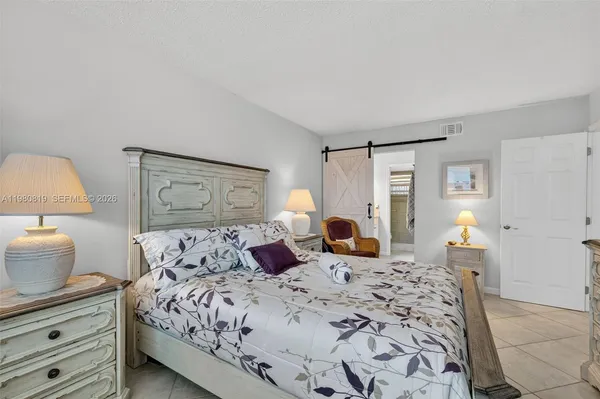 a bedroom with a large bed and a lamp