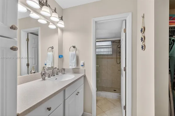 a bathroom with a double vanity sink mirror and shower