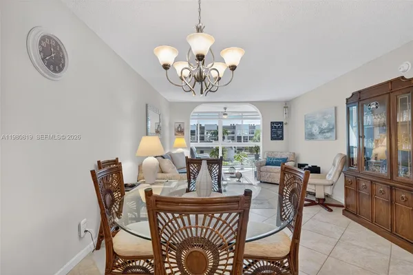 a view of a dining room with furniture a chandelier and wooden floor