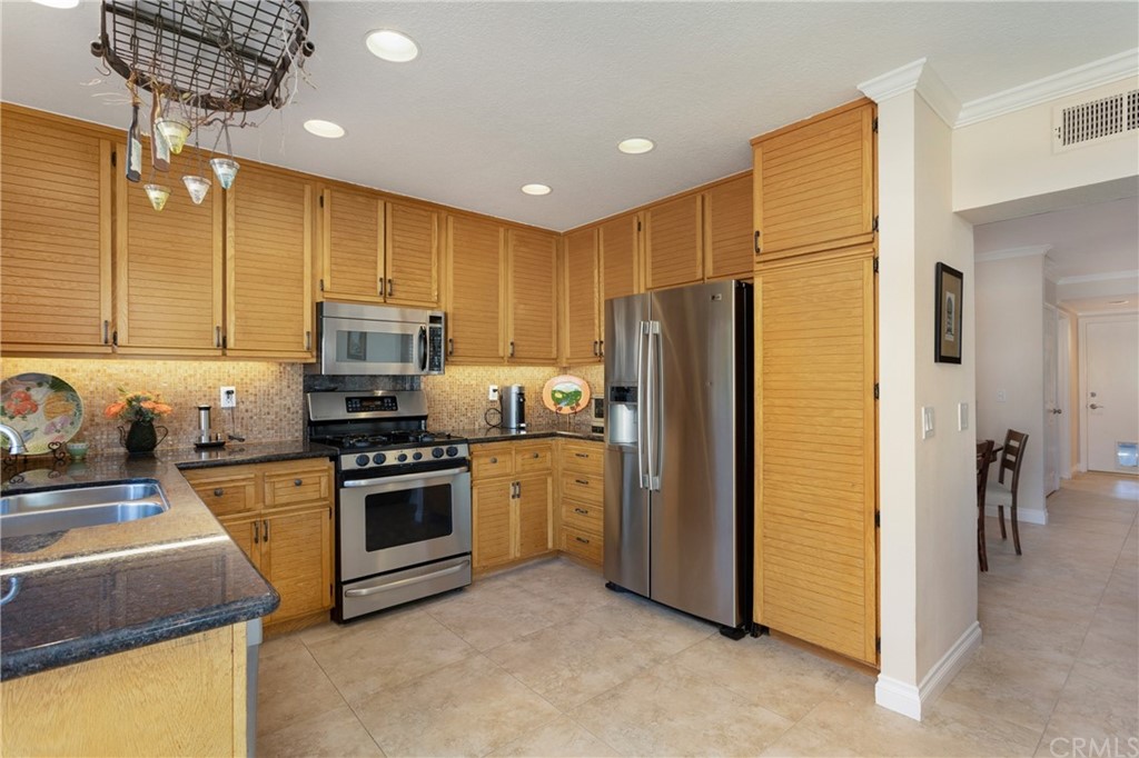 20 Stream Street Laguna Niguel, CA 92677 - Photo 5 of 28 a kitchen with stainless steel appliances granite countertop a refrigerator a stove a sink and a microwave