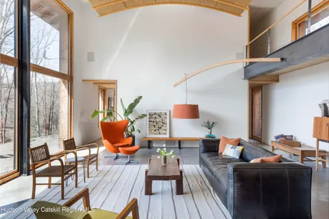 a living room with furniture a wooden floor and a large window