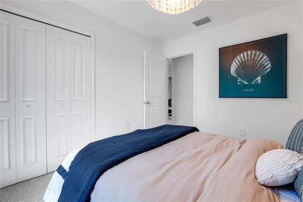 a bedroom with a bed dresser and a wooden floor