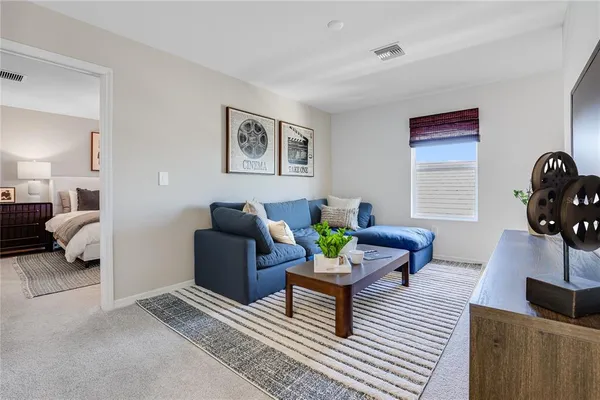 a living room with furniture a flat screen tv and a chandelier