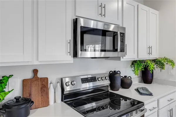 a kitchen with white cabinets and refrigerator