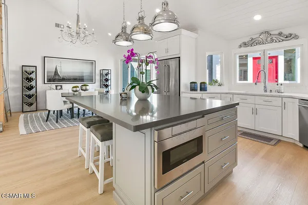 a kitchen with stainless steel appliances kitchen island granite countertop a table and chairs in it