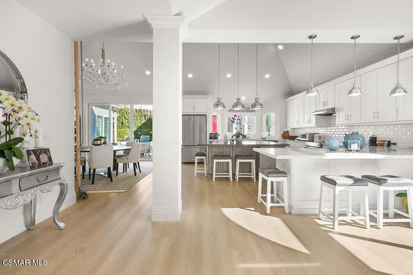 a kitchen with stainless steel appliances kitchen island granite countertop a table and chairs in it