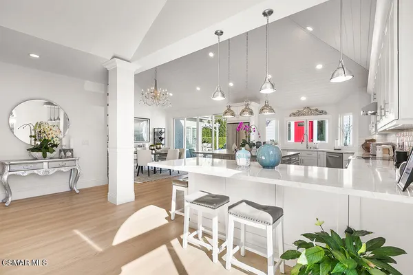 a kitchen with stainless steel appliances granite countertop kitchen island wooden floors and white cabinets