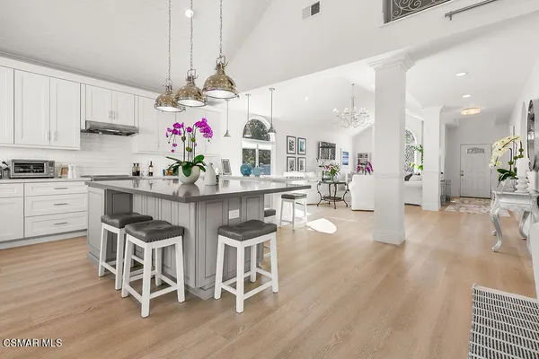 a kitchen with granite countertop a table chairs stove and cabinets