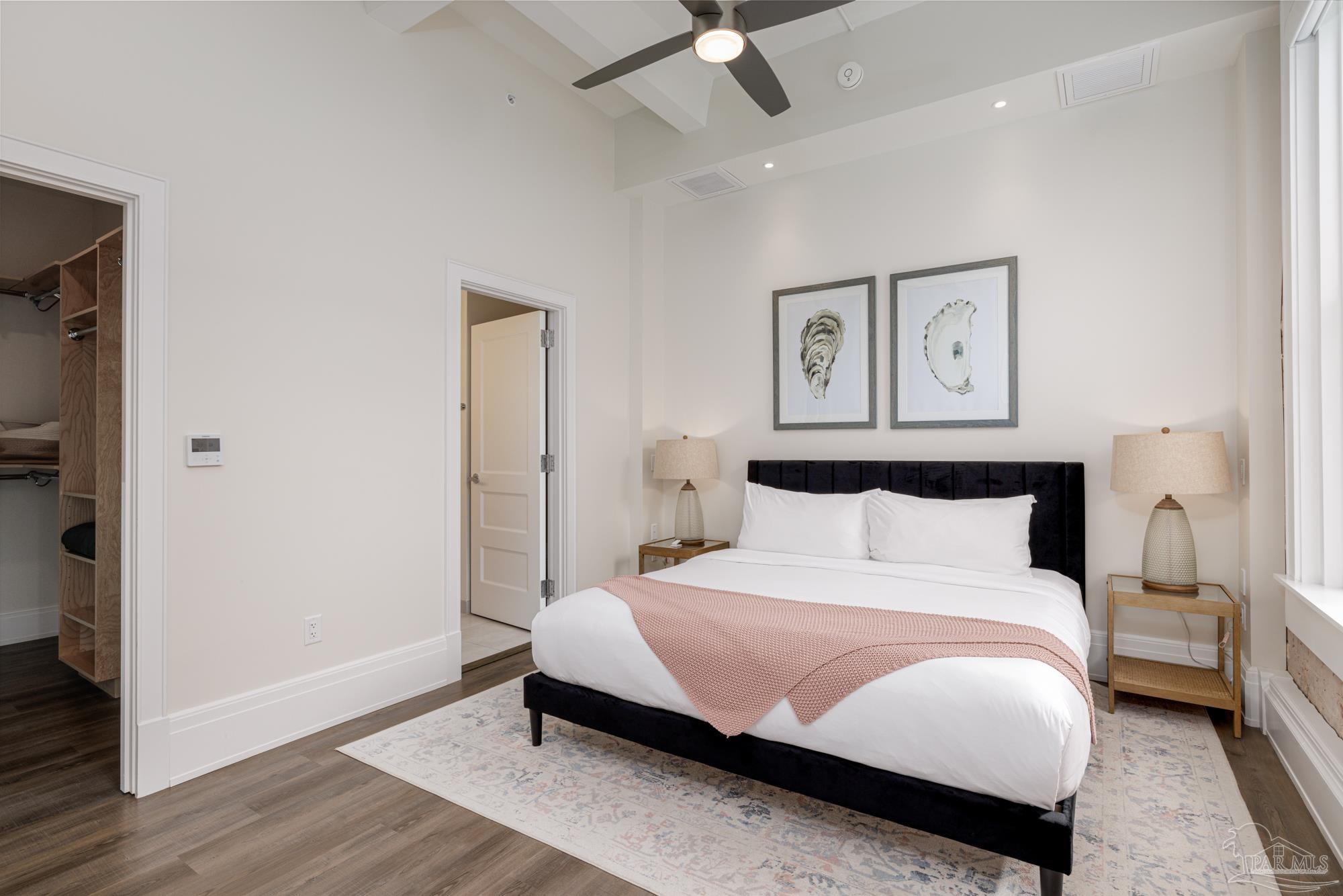 17 Palafox Place, Unit 307 Pensacola, FL 32502 - Photo 11 of 27 a bedroom with a bed and a chandelier