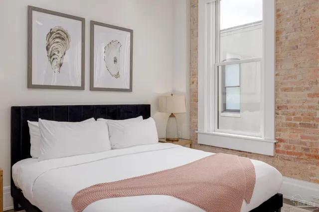 a bedroom with a bed and painting on the wall