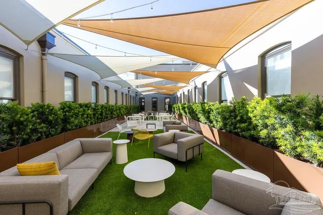 a view of a patio with couches table and chairs and potted plants