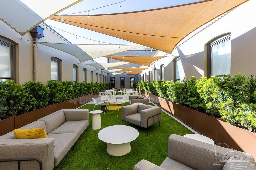 17 Palafox Place, Unit 307 Pensacola, FL 32502 - Photo 23 of 27 a view of a patio with couches table and chairs and potted plants
