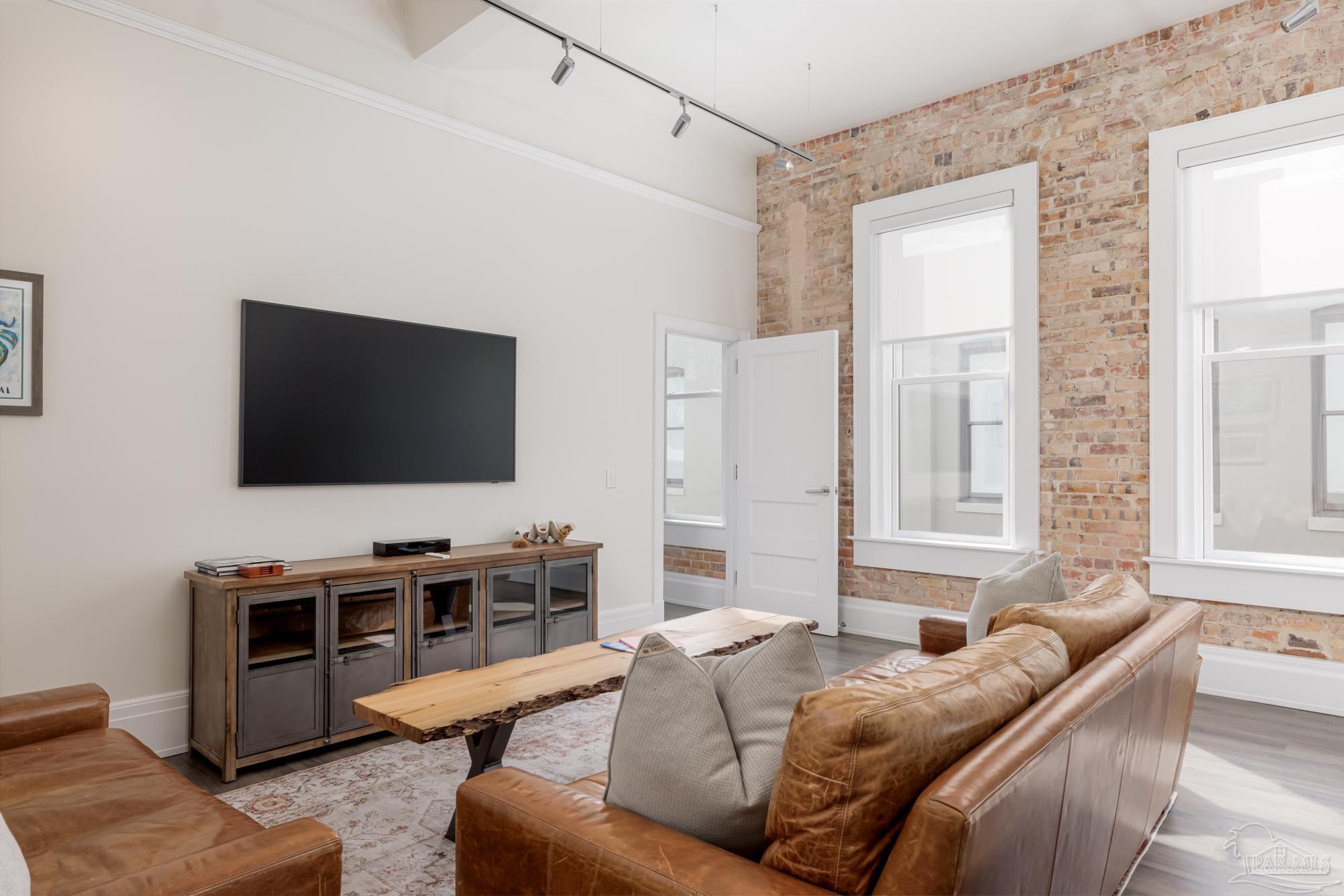 17 Palafox Place, Unit 307 Pensacola, FL 32502 - Photo 4 of 27 a living room with furniture and a flat screen tv