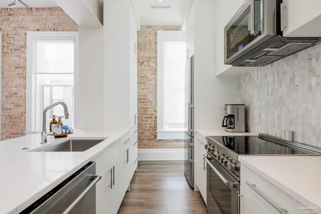 a kitchen with stainless steel appliances granite countertop a sink and a stove