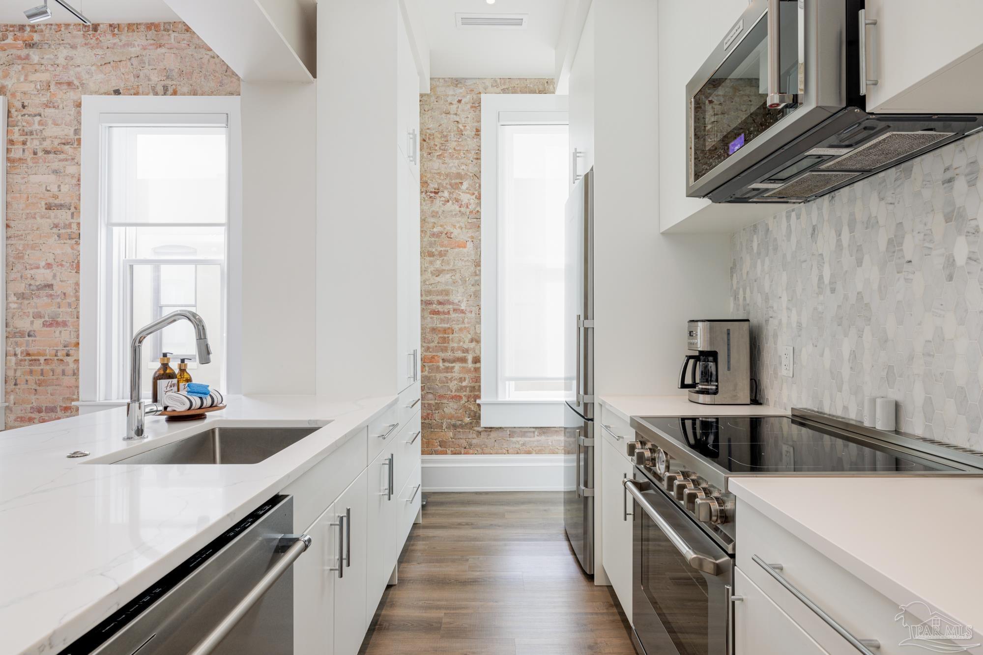 17 Palafox Place, Unit 307 Pensacola, FL 32502 - Photo 6 of 27 a kitchen with stainless steel appliances granite countertop a sink and a stove
