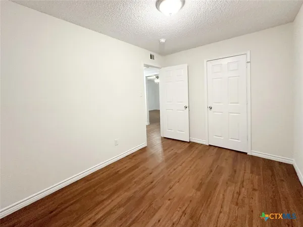 a view of an empty room with wooden floor