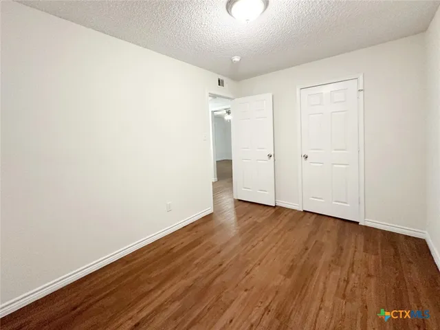 a view of an empty room with wooden floor