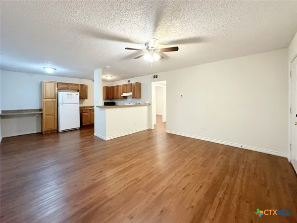 a view of a kitchen with a sink and a refrigerator