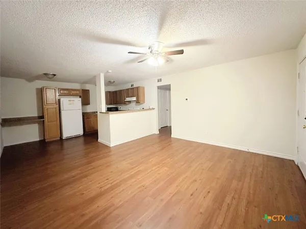 a view of a kitchen with a sink and a refrigerator