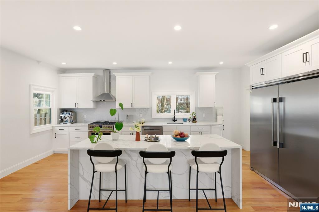 403 Lawn Ridge Road Orange, NJ 07050 - Photo 9 of 45 a kitchen with stainless steel appliances a dining table chairs and wooden floor