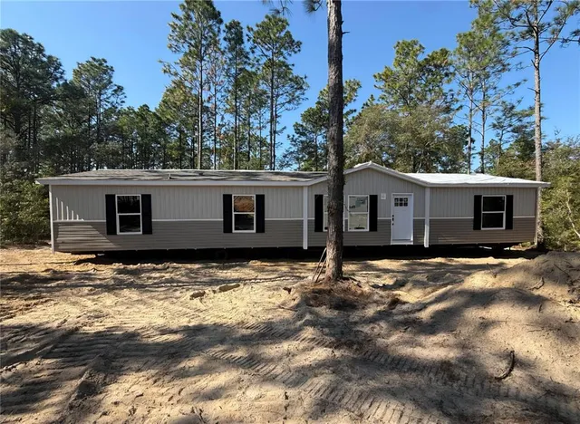 a view of a house with a yard covered in snow