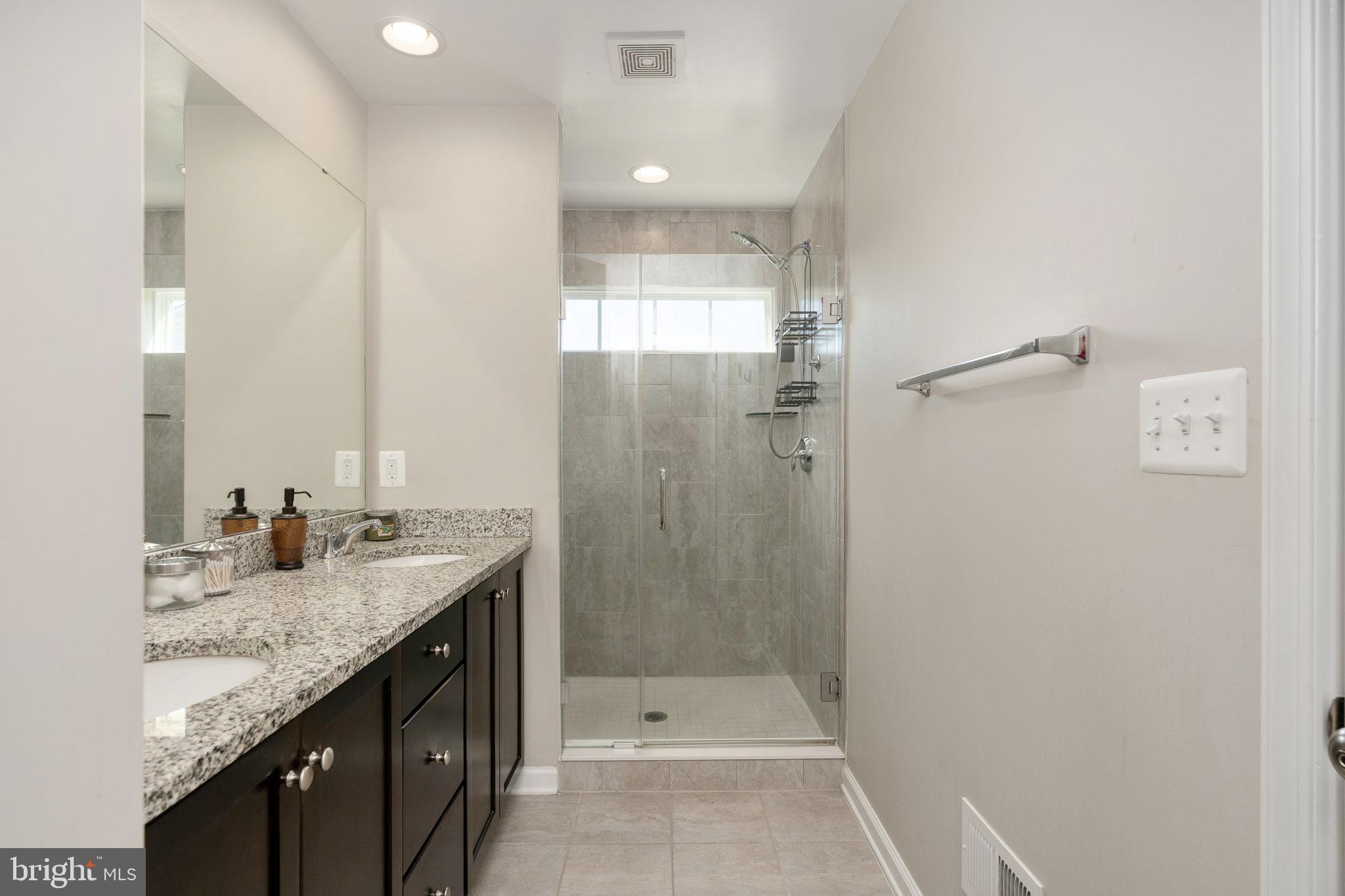 650 Aspen Road, Unit 108 Stafford, VA 22554 - Photo 23 of 30 a bathroom with a granite countertop sink a shower and a mirror