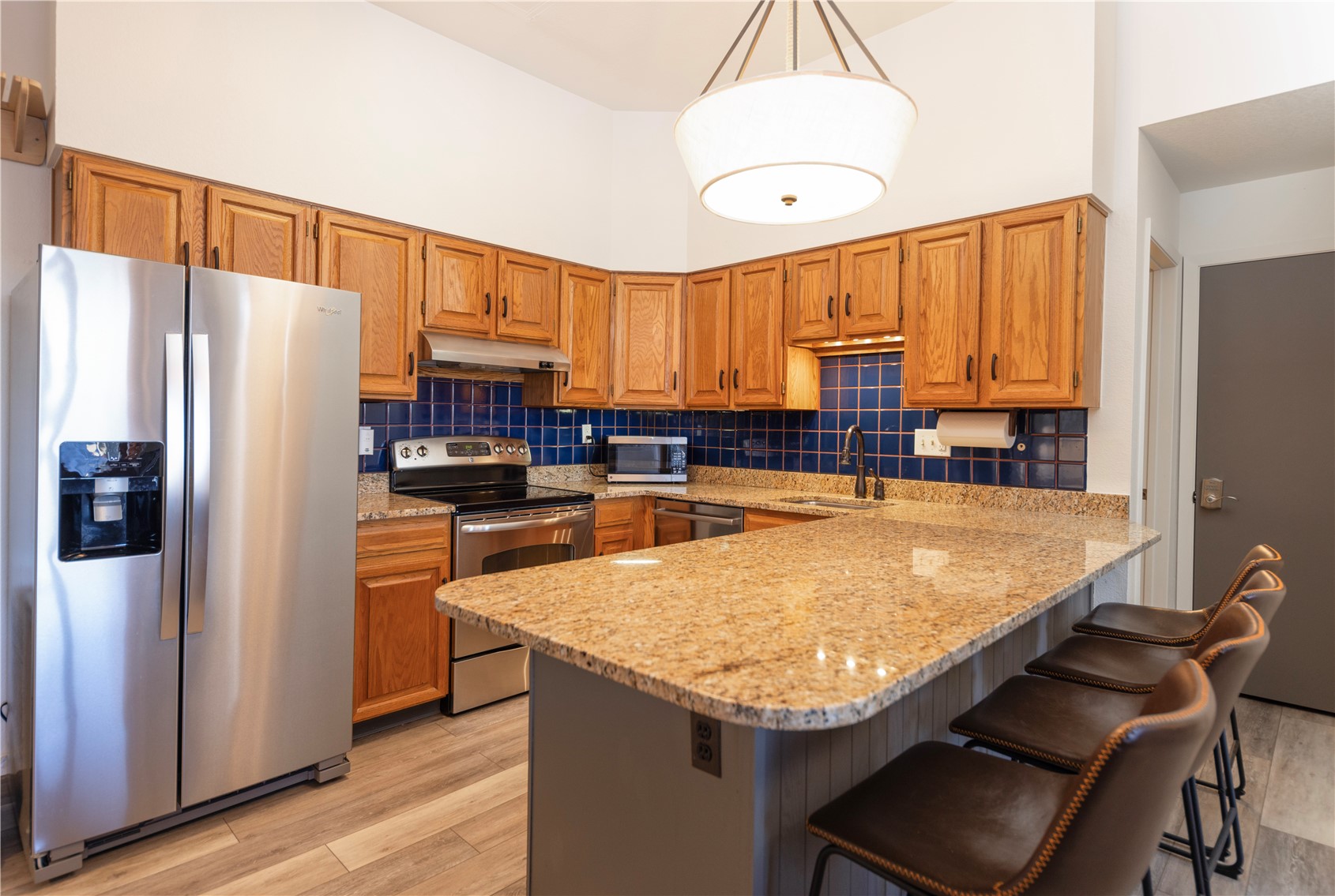 89410 Ryan Gulch Road, Unit 104 Silverthorne, CO 80498 - Photo 4 of 31 a kitchen with granite countertop a refrigerator a stove and a sink