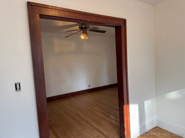 61 Cheshire Road Wallingford, CT 06492 - Photo 8 of 16 an empty room with wooden floor and mirror