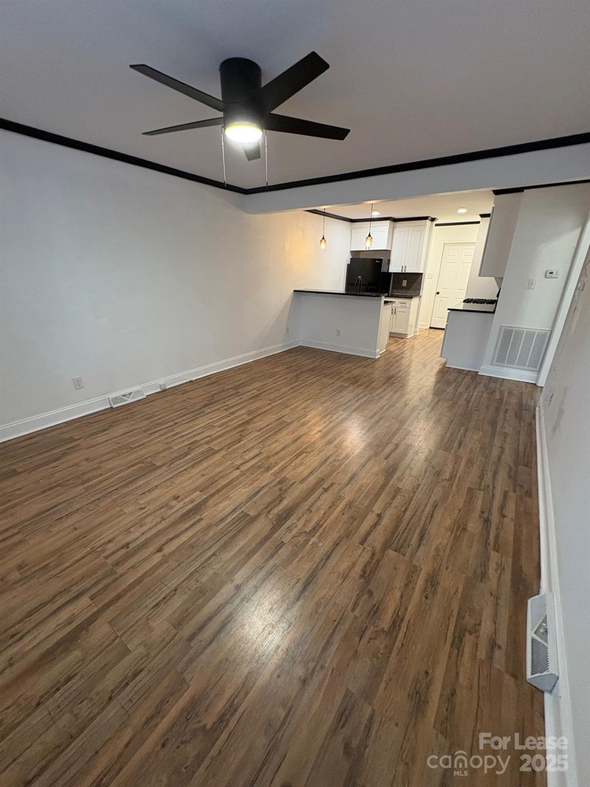 19716 Smith Circle, Unit B Cornelius, NC 28031 - Photo 2 of 8 an empty room with wooden floor and windows
