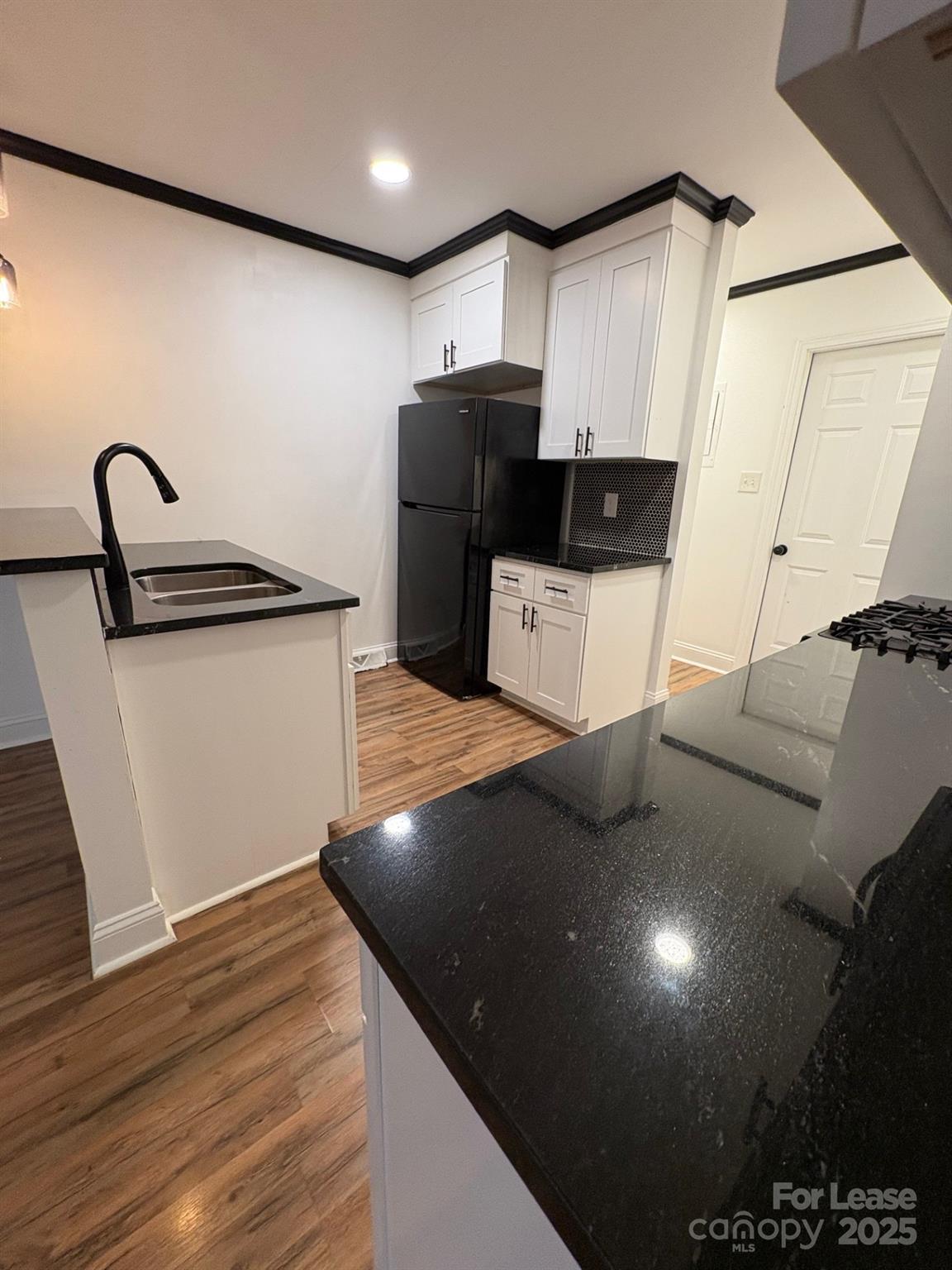 19716 Smith Circle, Unit B Cornelius, NC 28031 - Photo 3 of 8 a kitchen with stainless steel appliances a refrigerator sink and cabinets