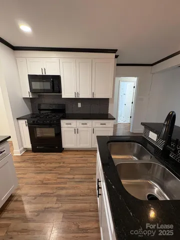 a kitchen with granite countertop a sink and a stove top oven
