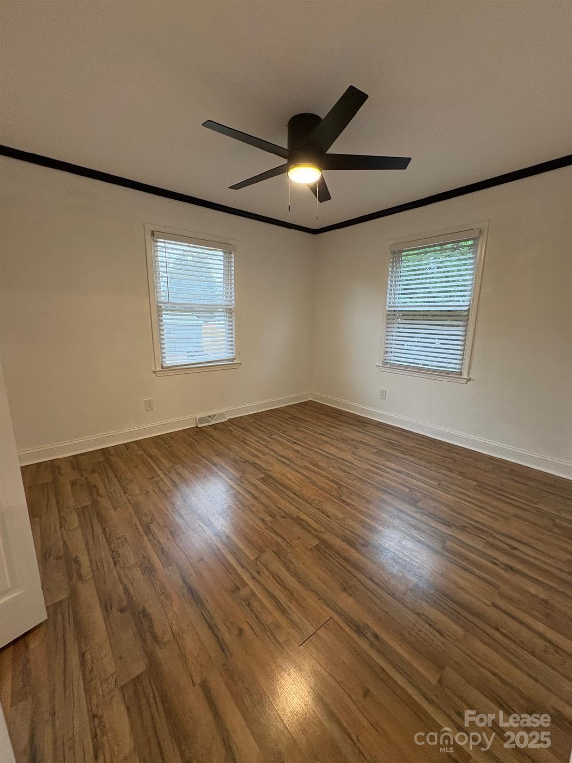 19716 Smith Circle, Unit B Cornelius, NC 28031 - Photo 5 of 8 a view of an empty room with wooden floor and a ceiling fan