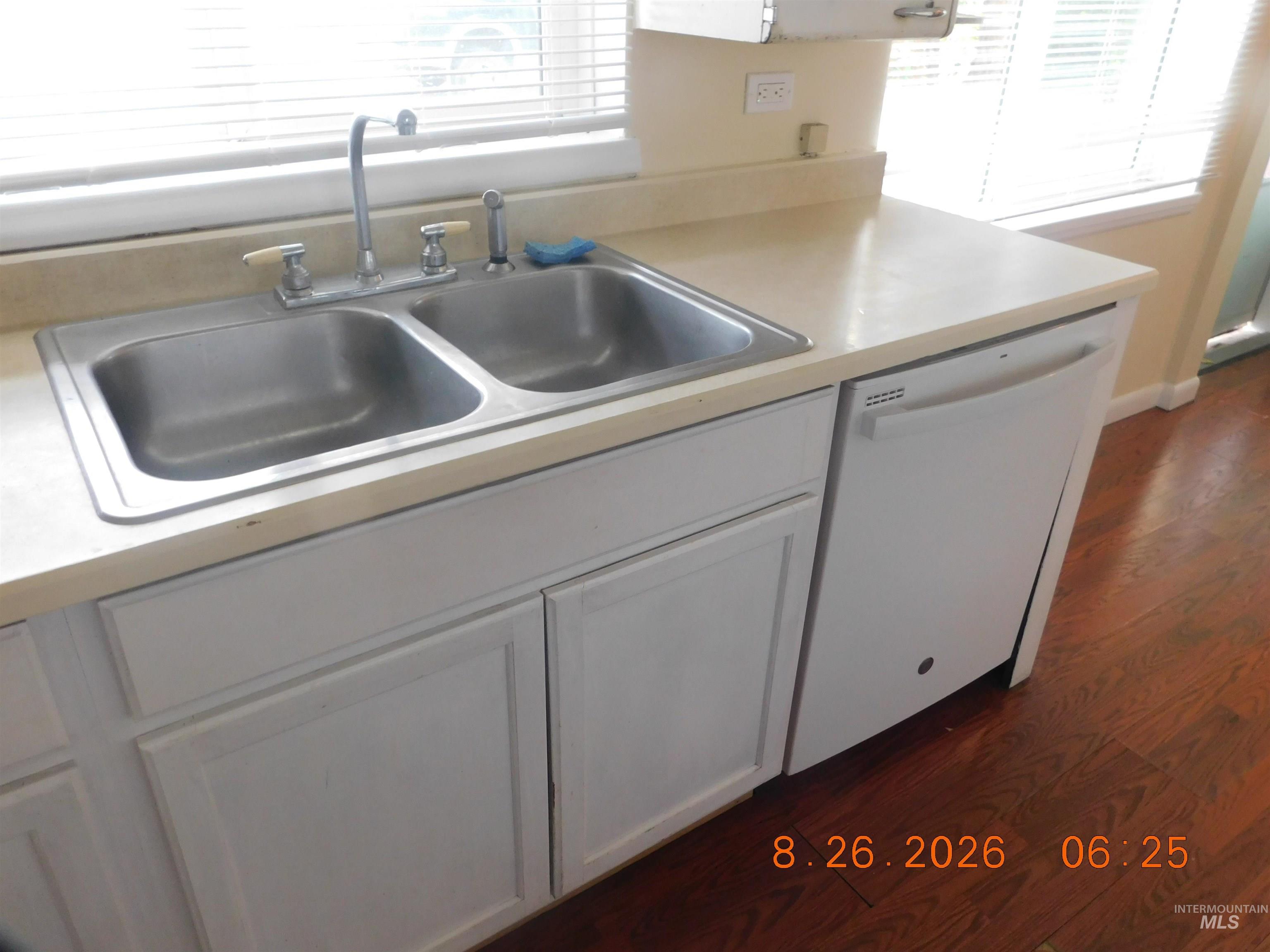 2115 North Galena Road Council, ID 83612 - Photo 11 of 18 White cabinetry with a double basin stainless steel sink, a white built-in dishwasher, and a light-toned countertop