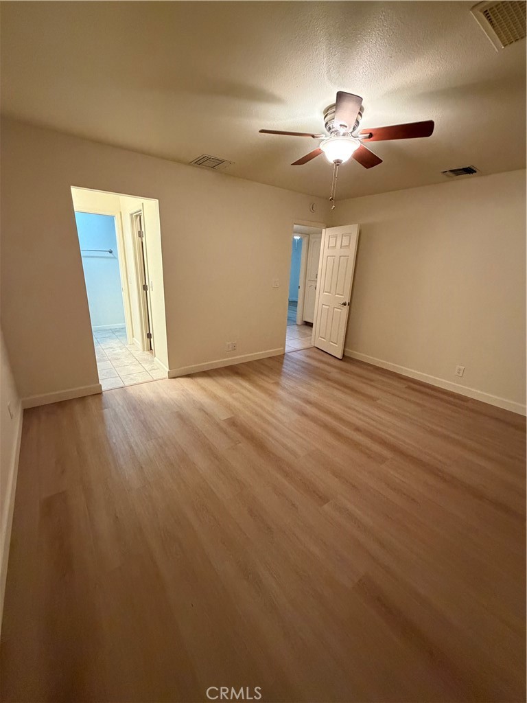 209 Kimberly Lane Ridgecrest, CA 93555 - Photo 54 of 62 an empty room with wooden floor chandelier fan and windows