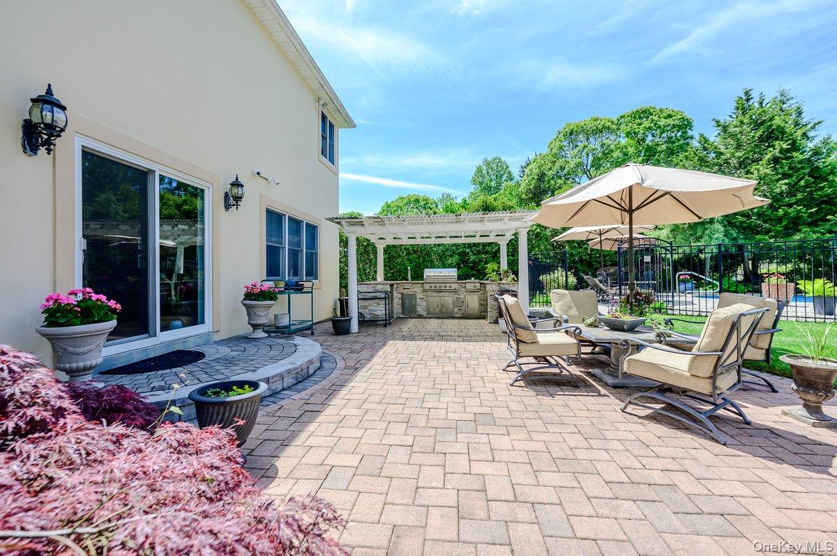 129 Round Swamp Road Huntington, NY 11743 - Photo 39 of 49 Expansive paver patio with a built-in outdoor kitchen under a pergola