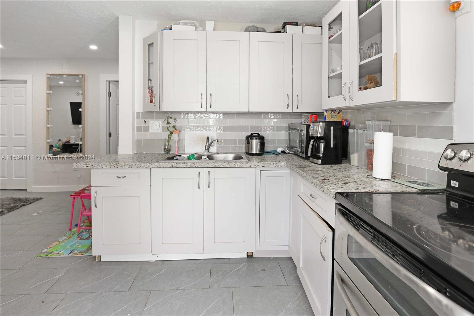 1810 Northwest 34th Street Miami, FL 33142 - Photo 15 of 33 a kitchen with stainless steel appliances granite countertop a sink and cabinets