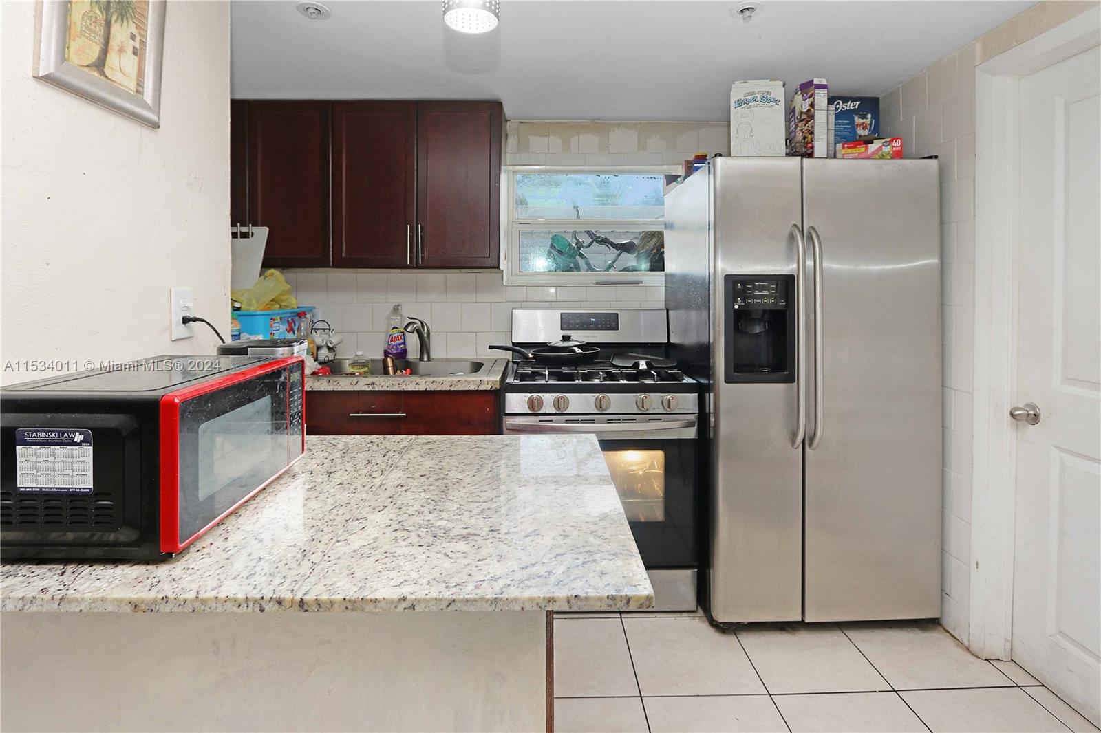 1810 Northwest 34th Street Miami, FL 33142 - Photo 23 of 33 a kitchen with stainless steel appliances granite countertop a refrigerator stove and sink